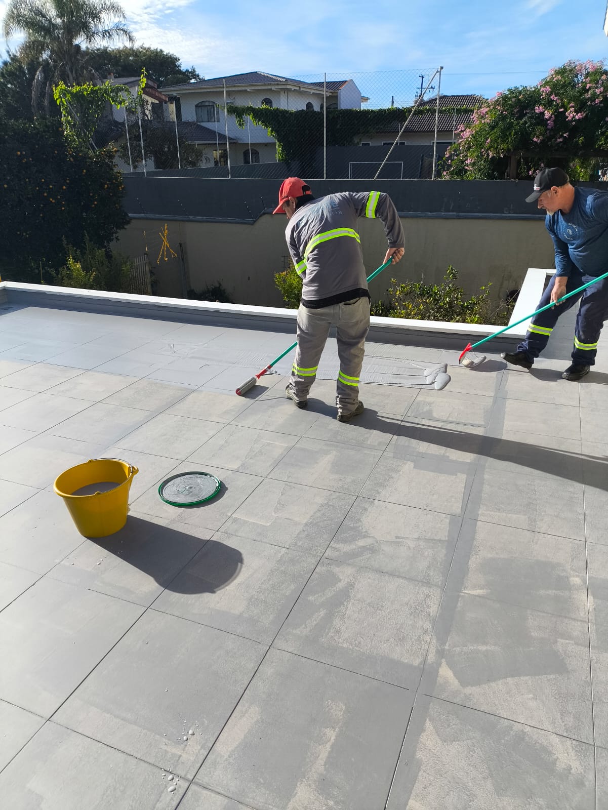 Equipe da AR4 aplicando impermeabilizante em piso de laje